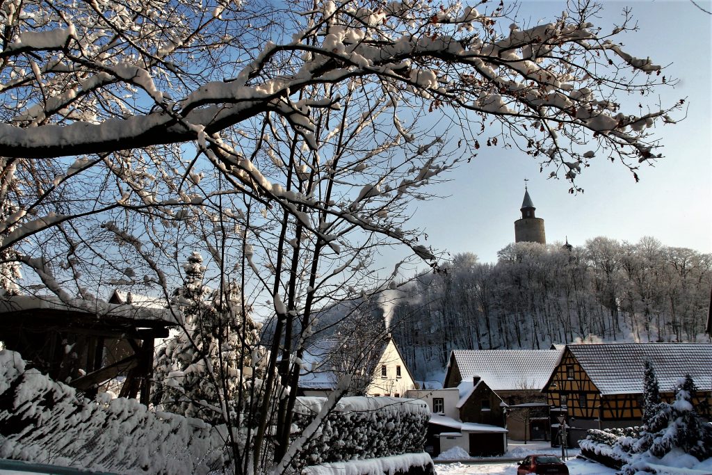 Posterstein im Winter mit Schnee und Burg im Hintergrund